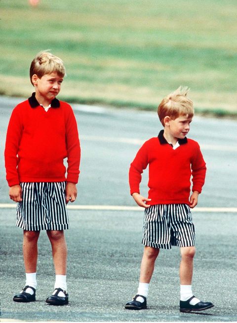 Prince William, Prince Harry Prince William and Prince Harry, wearing identical red jumpers and stripey shorts, arrive at Aberdeen Airport at the start of their holidays in Scotland in August 1989 in Aberdeen, Scotland. (Photo by Anwar Hussein/Getty Images)