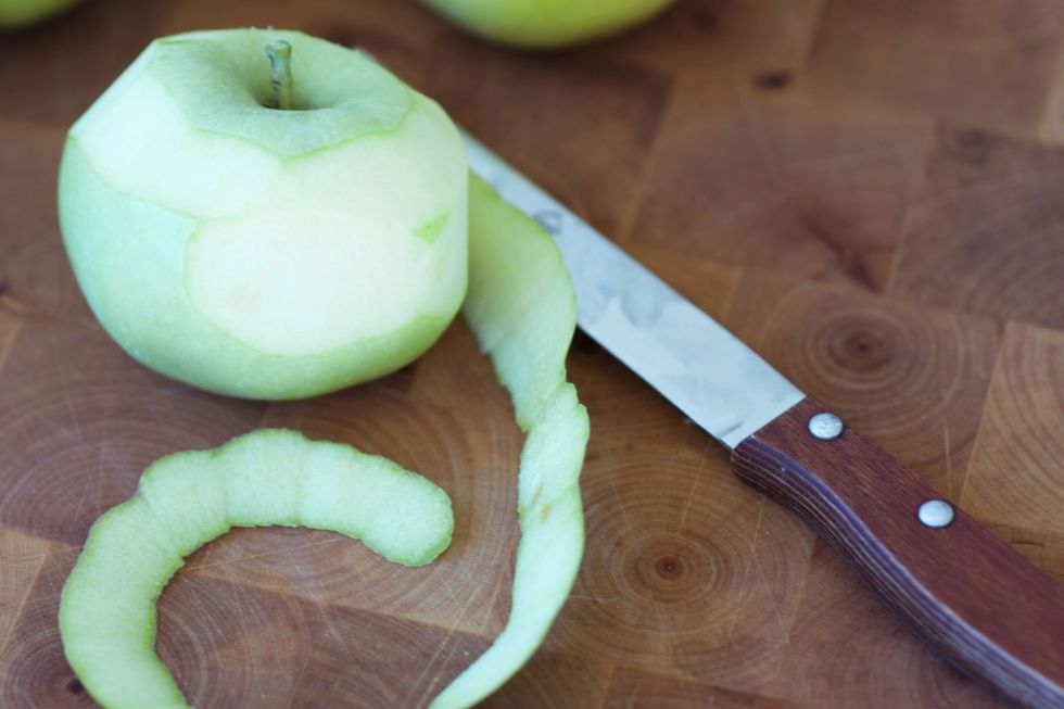 Apple peel on chopping board with knife
