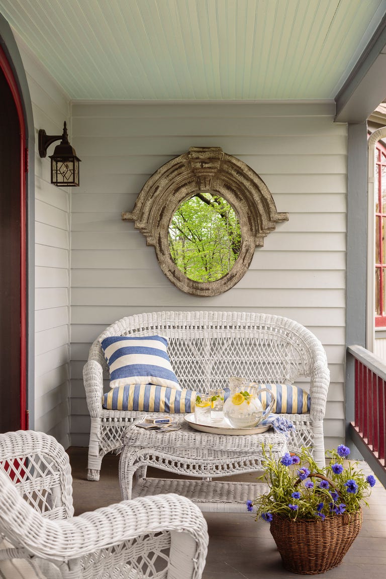 Vintage style white wicker furniture on a front porch with dramatic Old World mirror. #frontporch #decoratingideas #wicker #furniture