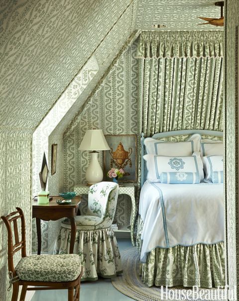 An attic guest room is Kincaid's homage to legendary designer Sister Parish, whose classic Dolly fabric makes the tiny space feel as fresh as a spring meadow. A John Rosselli bedside table holds a Christopher Spitzmiller lamp. Bedding, Leontine Linens. Floor painted in Farrow &amp; Ball's Dix Blue.