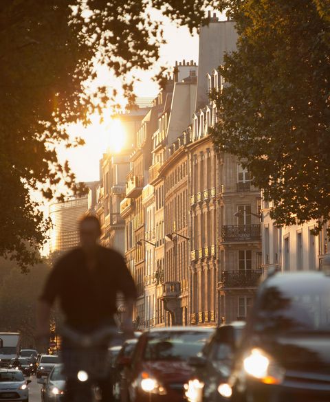 The busy, early morning commute passes the iconic Haussmann architecture at dawn in Paris, France