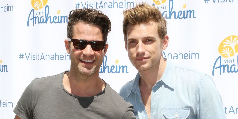 nate berkus and jeremiah brent in front of a stand and repeat