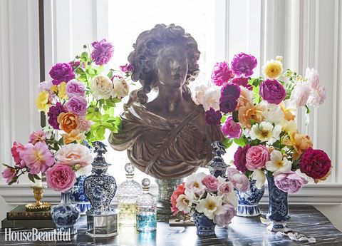 console table with a display of a bust and flowers