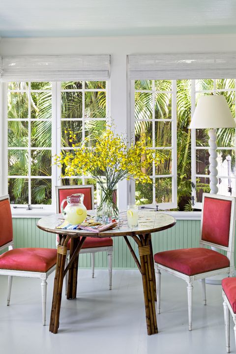 todd romano florida house dining room with red chairs and rattan table