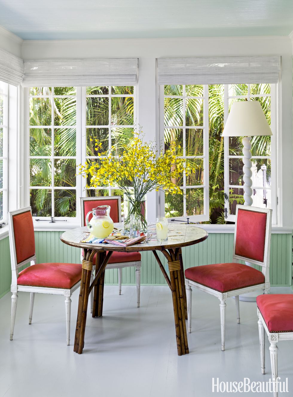 todd romano florida house dining room with red chairs and rattan table