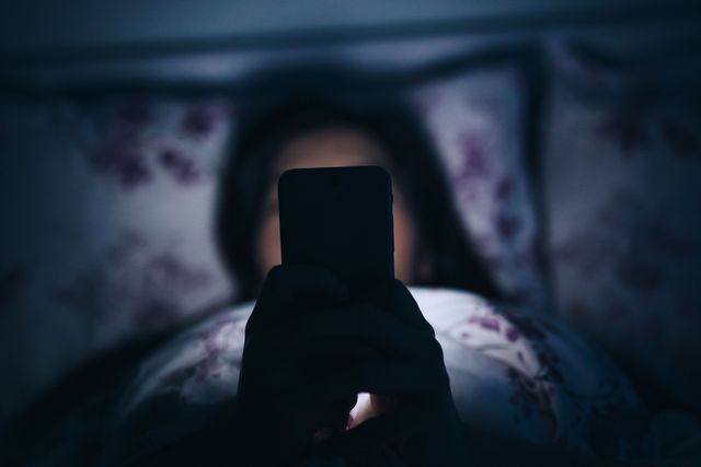 woman in bed with phone