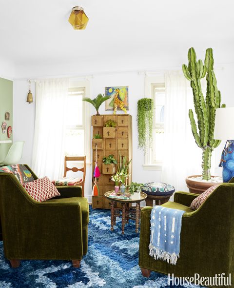 The living room is anchored by a tall euphorbia plant, which is similar to a cactus but needs less sunlight. The Fable rug is from Blakeney's collection for Loloi, the curtains are from Ikea and the rods are from Lowe's.