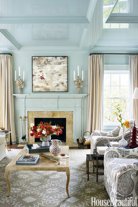 In the living room, custom-colored lacquer was applied for a sleek, unified surface. The Pierre armchairs from Bunny Williams Home are in a Jasper fabric by Michael S. Smith. The photograph over the mantel is by William T. Hillman.