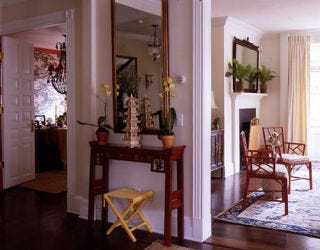 White hallway with flowers and a yellow stool.