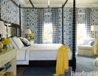 blue and yellow bedroom with patterned wall paper and four poster bed