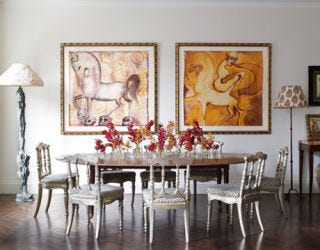 dining room with two water color paintings hanging on wall behind table
