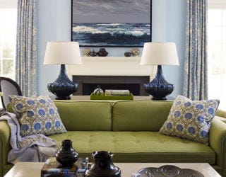 green and blue living room with green sofa and painting of the ocean