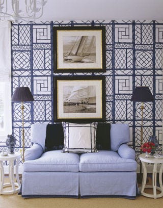 Blue and white guest room with blue sofa.