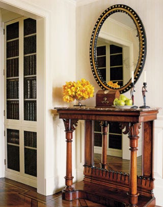 antique table and mirror featured in an entryway