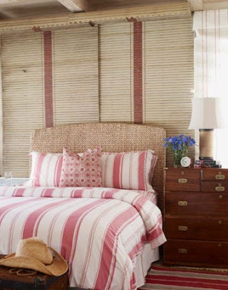 bedroom with light red stripes on bed, curtains, and carpet