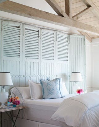 master bedroom with seafoam barn door headboard and white bedding