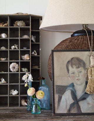 portrait against a brown wicker lamp next to small flower vase