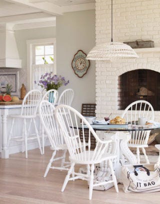 white kitchen dining table area with fireplace