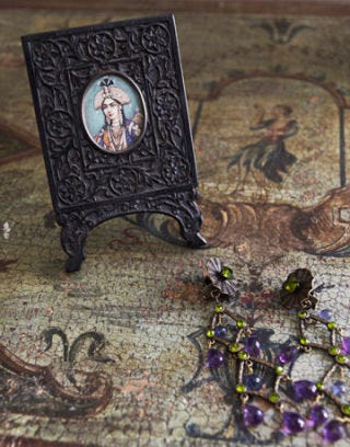 miniature portrait in black frame on venetian painted commode