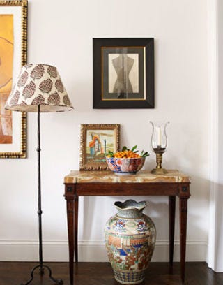 corner of the dining room with floor lamp urn and onyx topped console