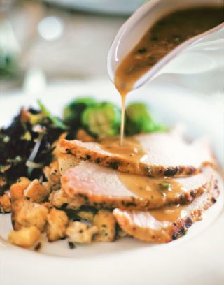 plate with sliced turkey and gravy drizzle