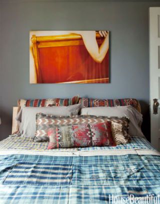 bright photograph print hanging above bed on gray walls