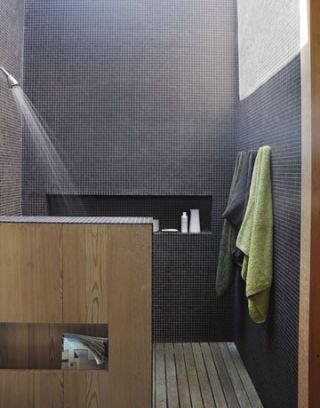 shower in bathroom with black tiles