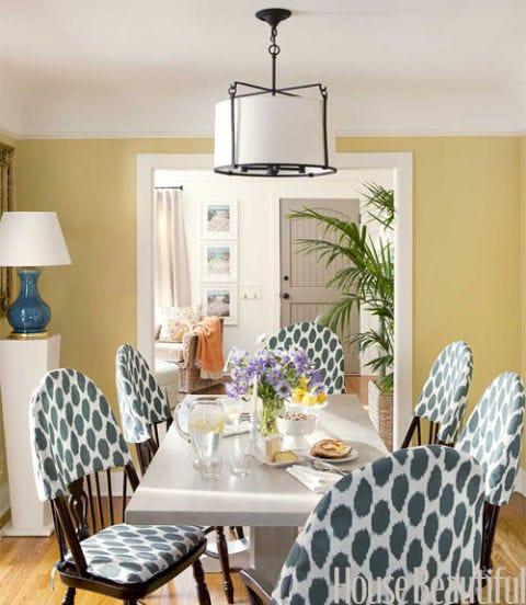 yellow painted dining room with ikat seat covers