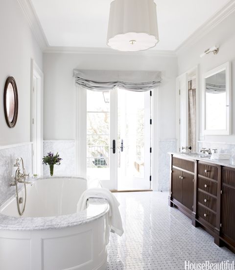 white bathroom with oval tub and polished tile