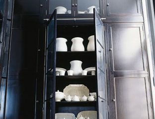 black cabinets in pantry of kitchen holding white china