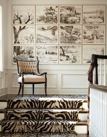 a staircase with zebra print carpeting and a mural of landscape on the wall