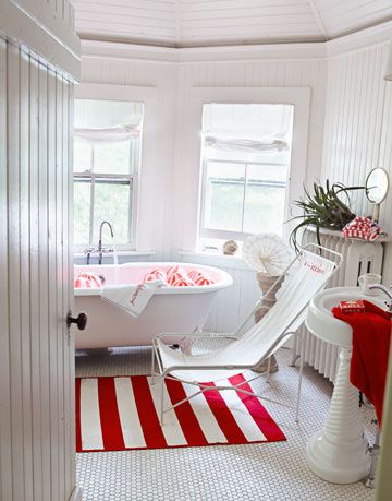 a door opening into a white bathroom with red accents