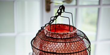 a lantern sitting on a table with a bottle of wine and some dishes