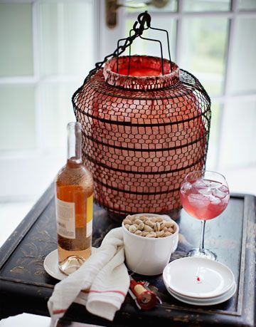 a lantern sitting on a table with a bottle of wine and some dishes