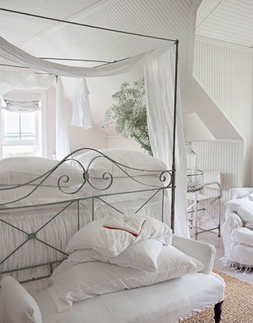 a white bench in front of a white bed