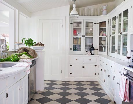 a black and white tile floor in a white kitchen