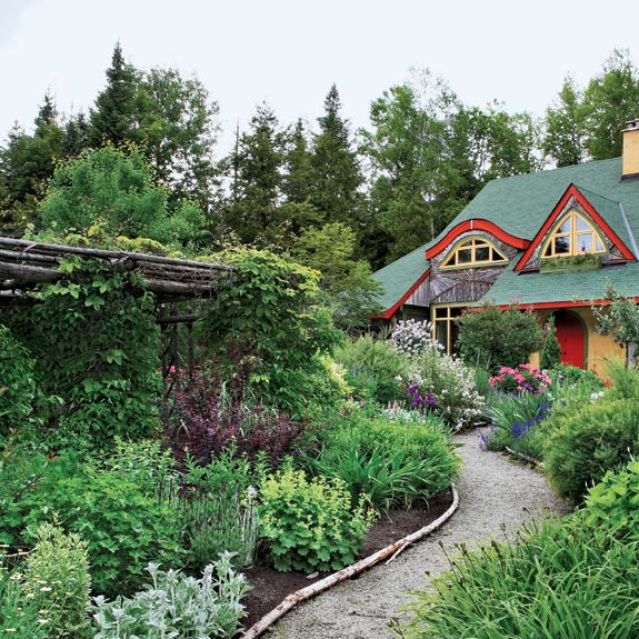 cottage with yellow and red trim and lush garden