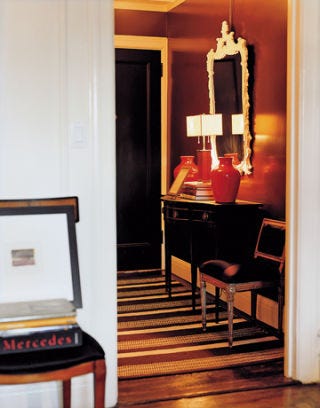dark entryway with chairs a mirror and table
