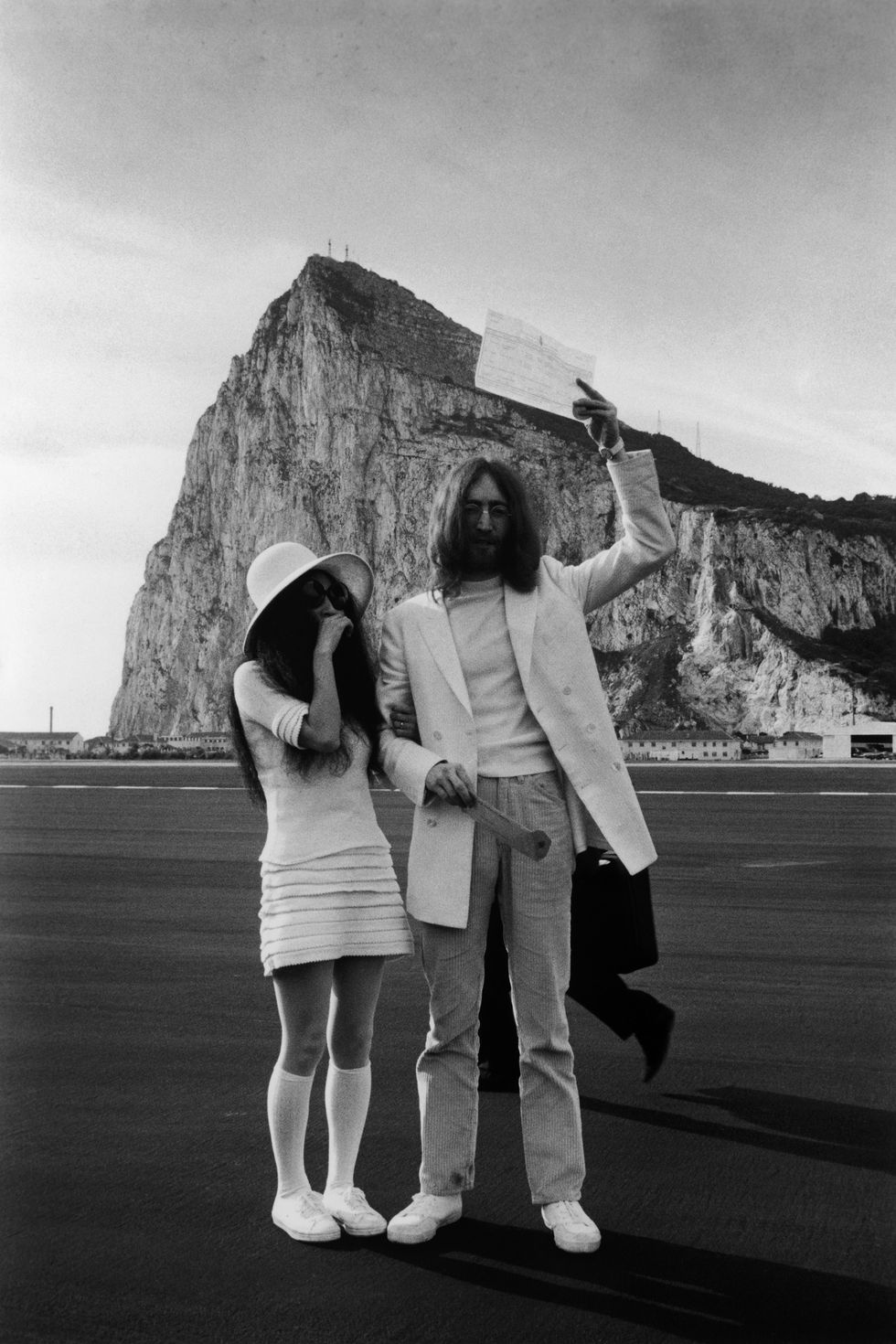 John Lennon and Yoko Ono, both dressed in white, with their marriage certificate after their wedding in Gibraltar, 20th March 1969. (Photo by Simpson/Express/Getty Images)
