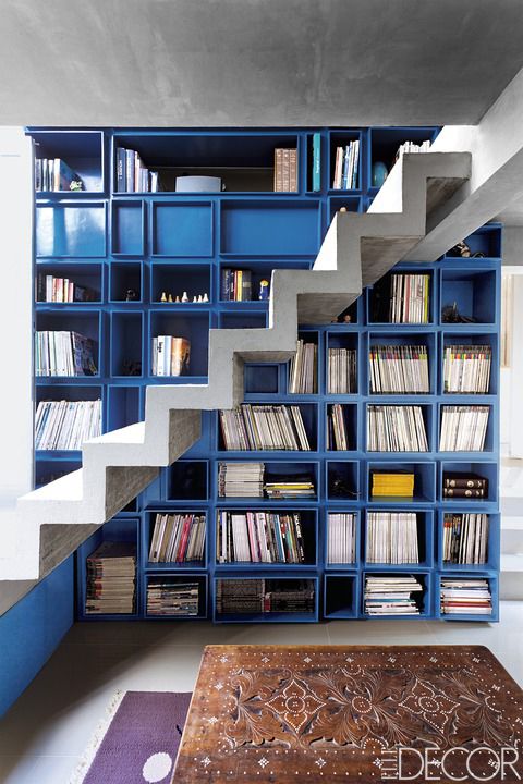 <p>Ino Caluza, owner of the custom-denim brand Viktor, looked to the work of Mexican architect Luis Barragán when designing his family home near Manila in the Philippines. The bright blue bookcase in the two-story library stands out against the concrete staircase and subdued furnishings.</p>