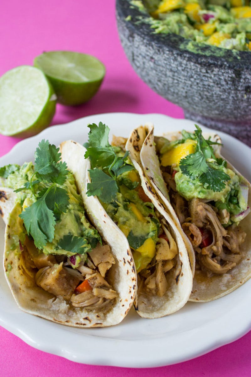 <p><a href="http://sweetpotatosoul.com/2016/05/jerk-jackfruit-tacos.html" target="_blank">Jerk Jackfruit Tacos</a></p><p>By Jenné Claiborne of <a href="http://sweetpotatosoul.com/" target="_blank">Sweet Potato Soul</a></p><p>Prep Time: 20 mins. Cook time: 35 mins. Total time: 55 mins. </p><p>Serves: 4</p><p><strong>Ingredients: </strong></p><ul>
<li>2 20-oz cans of young green jackfruit in brine (do not use jackfruit in syrup for this)</li>
<li>2 small red bell peppers, chopped</li>
<li>1 cup yellow onion, chopped</li>
<li>3 green onions, white parts, chopped</li>
<li>3 garlic cloves, chopped (I forgot to add this in the video, and it was just as fantastic without)</li>
<li>1 habanero chili, ½ if you like it less spicy, OR ½ Thai chili</li>
<li>2 tsp ginger, minced</li>
<li>3 tbsp lime juice</li>
<li>1 tbsp apple cider vinegar</li>
<li>6 tbsp shoyu</li>
<li>2 tsp maple syrup, or agave or coconut nectar</li>
<li>1 tsp ground allspice</li>
<li>pinch of nutmeg</li>
<li>1 tbsp fresh thyme (I only had Italian seasoning the last time I made this, and it was perfect)</li>
<li>1 tbsp black pepper</li>
<li>1 vegetable bouillon cube + 1 ½ cups water (or 1½ cups vegetable stock)</li>
<li>8 corn tortillas, warmed before serving</li>
</ul><p><em>Mango Guacamole</em></p><ul>
<li>2 ripe avocados, cubed</li>
<li>1 ½ cup ripe mango, cubed</li>
<li>¼ cup red onion, diced</li>
<li>½ cup cilantro, chopped</li>
<li>juice of 2 limes</li>
<li>½ tsp sea salt</li>
<li></li>
</ul><p><strong>Directions: </strong></p><ul>
<li>Drain the jackfruit in a colander.</li>
<li>In a wide bowl, use a fork to pull the fibers apart. The jackfruit should have a texture reminiscent of pulled chicken.</li>
<li>Place the jackfruit and chopped red pepper in a large pot or skillet with a lid, and set aside.</li>
<li>Place the sauce ingredients (onion to bouillon) in a blender, and blend until it has become a smooth liquid.</li>
<li>Pour the sauce over the jackfruit, and stir to coat.</li>
<li>Place the pot on the stove, and bring contents to a simmer. Reduce heat to medium-low, cover the pot, and cook for 30 minutes.</li>
<li>While the jerk jackfruit is cooking, make your mango guacamole.</li>
<li>Place the guacamole ingredients in a mortar and pestle (or bowl and fork) and mash until your desired texture is reached. I like mine with some chunks in it. Set aside.</li>
<li>Serve the jerk jackfruit inside of warmed corn tortillas and topped with mango guacamole.</li>
</ul>