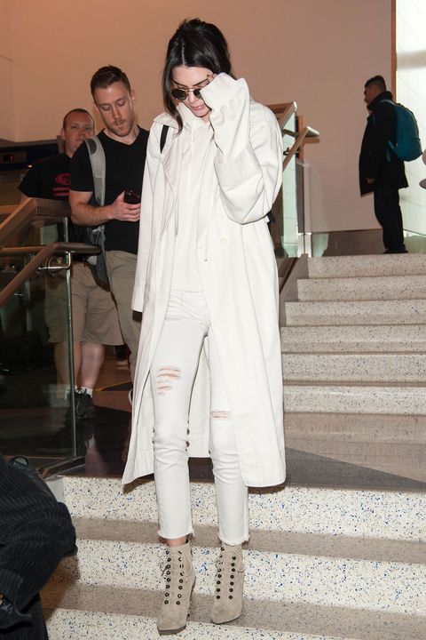 <p>Kendall Jenner covers her white jeans and top with a sweeping trench.</p>