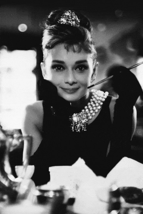 <p>What's more glamorous than Hepburn in this black dress, cigarette holder placed elegantly in hand, jewelry dripping from her neck as Holly Golightly in <i>Breakfast at Tiffany's</i>? She can look put-together yet convey loneliness so perfectly.</p>