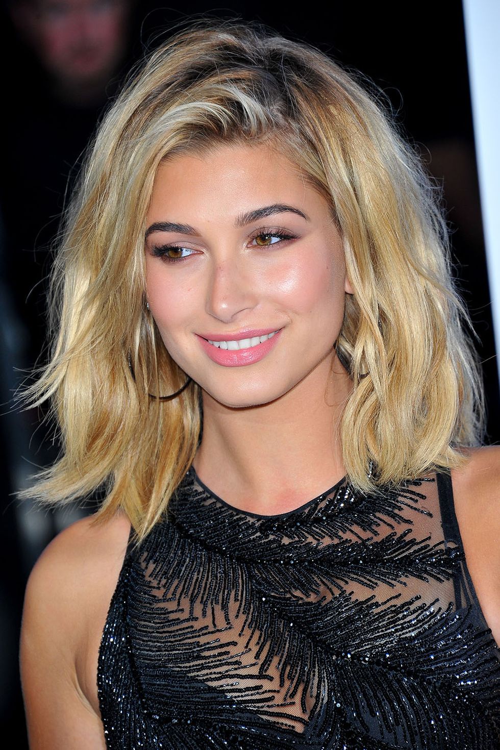 <p>Hailey Baldwin is on a '90s model hair kick. Here, her shoulder-length lob is flipped over to one side and styled in random bends.</p>
