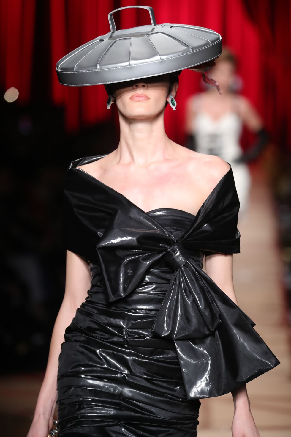 Models wearing a Moschino plastic bag, a Hefty bag dress topped