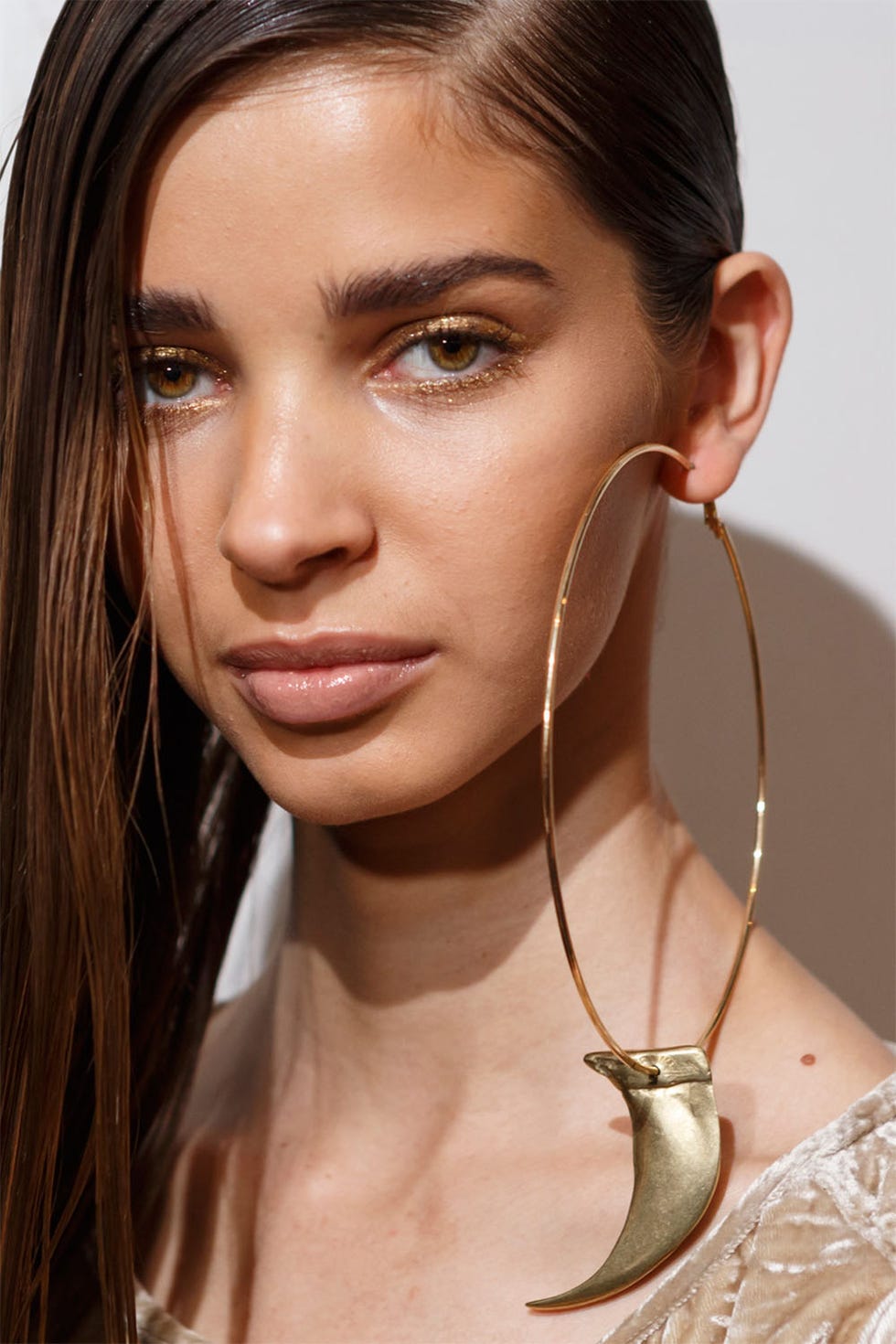 <p>Sleek hair and gold glitter eyes were just as cool as the oversize hoop earrings at Nicholas K. Backstage, makeup artist Sarah Lucero used the Stila Glitter &amp; Glow Liquid Eye Shadow in Golden Goddess to line both the upper and lower lashline. A little contouring enhanced the overall&nbsp;warm glow of the look, and Lucero finished with a swipe of Stila Apricot Lip Glaze, a pinky-nude shade with a slick finish.<span class="redactor-invisible-space"></span></p>