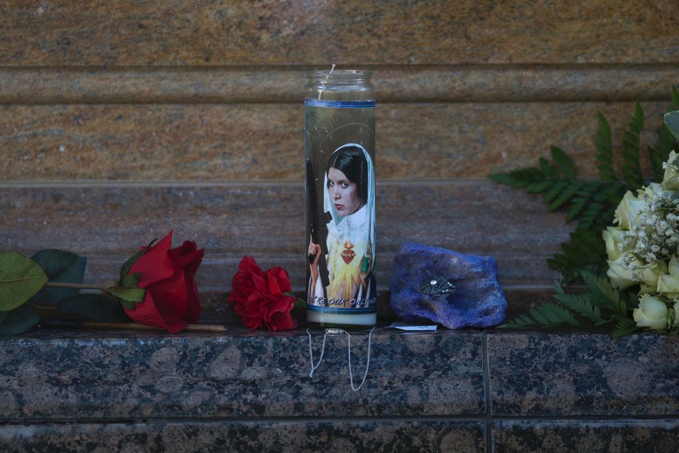 A candle featuring Carrie Fisher as Princess Leia is seen at her gravestone at Forest Lawn Cemetery.