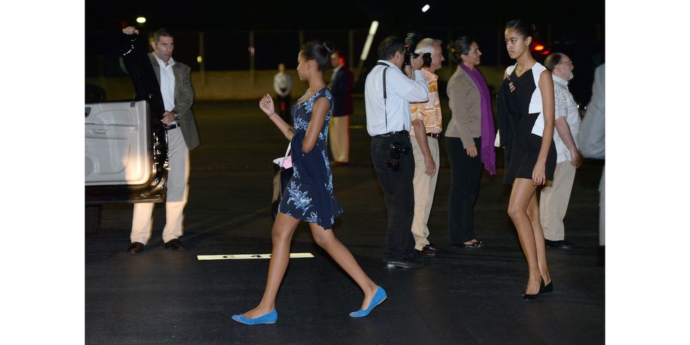 US First Daughters Malia (R) and Sasha (C) make their way upon arriving at Joint Base Pearl Harbor-Hickam in Honolulu, Hawaii, on December 20, 2013.  The First Family arrived in Hawaii to spend their vacation. AFP PHOTO/Jewel SAMAD        (Photo credit should read JEWEL SAMAD/AFP/Getty Images)