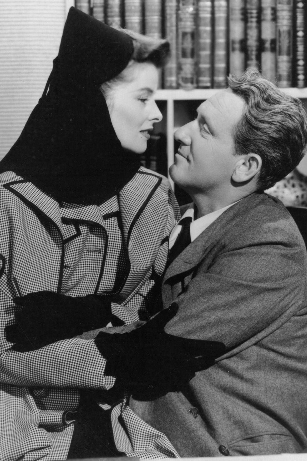 1942:  Katharine Hepburn (1907 - 2003) and Spencer Tracy (1900 -1967) embrace in a scene from the film 'Woman Of The Year', directed by George Stevens for MGM. The film describes the marriage of a sports columnist and a lady politician who have nothing in common save for their love for each other.  (Photo by Hulton Archive/Getty Images)