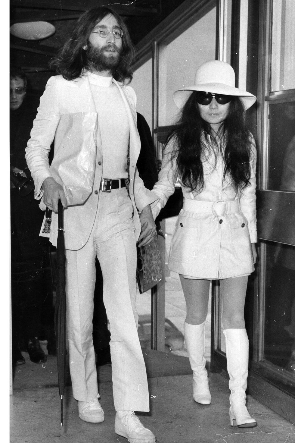 2nd April 1969:  Singer and songwriter John Lennon (1940 - 1980) and his wife artist Yoko Ono, both dressed in white at London Airport.  (Photo by Evening Standard/Getty Images)